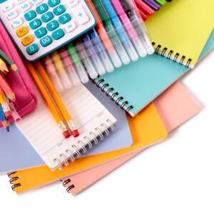 Various school supplies including notebooks, calculator and pink pencil case isolated against a white background
